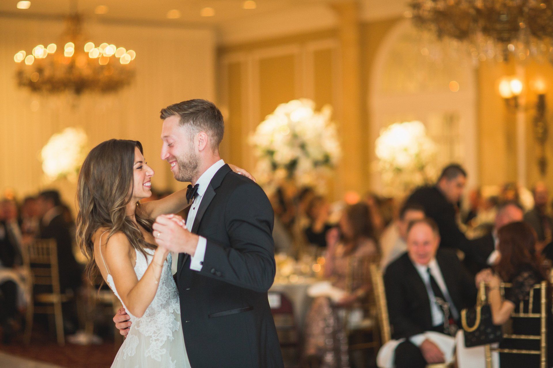 A bride and groom are dancing their first dance at their wedding reception.