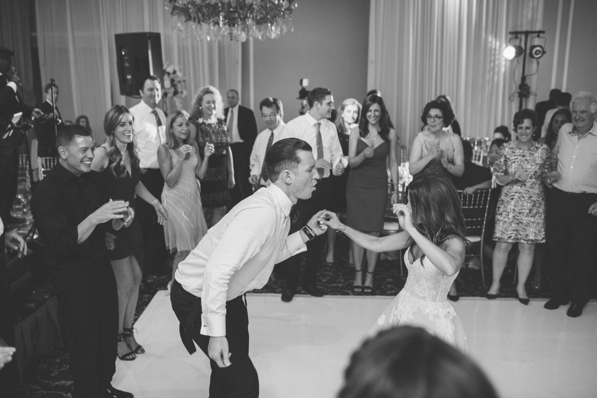 A black and white photo of a bride and groom dancing at a wedding reception.
