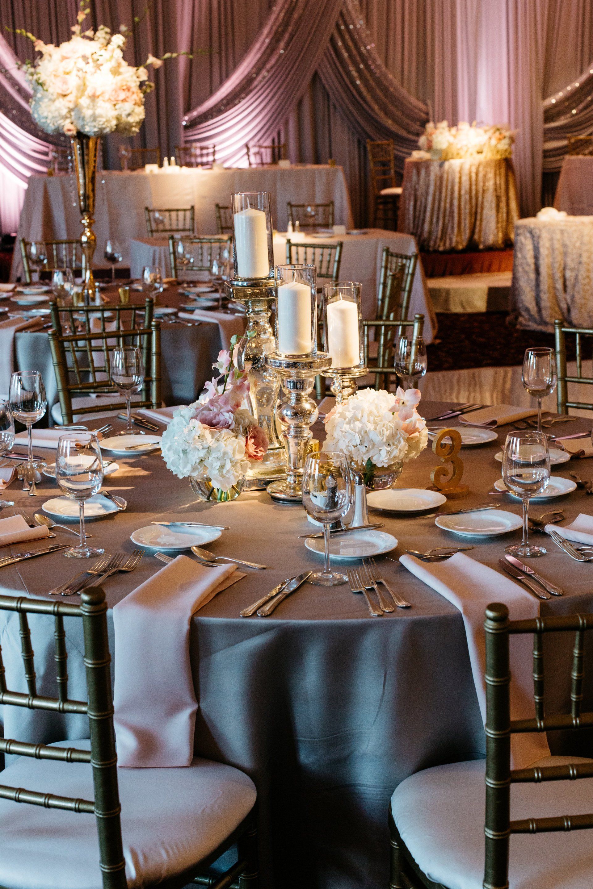 A room with tables and chairs set up for a wedding reception.