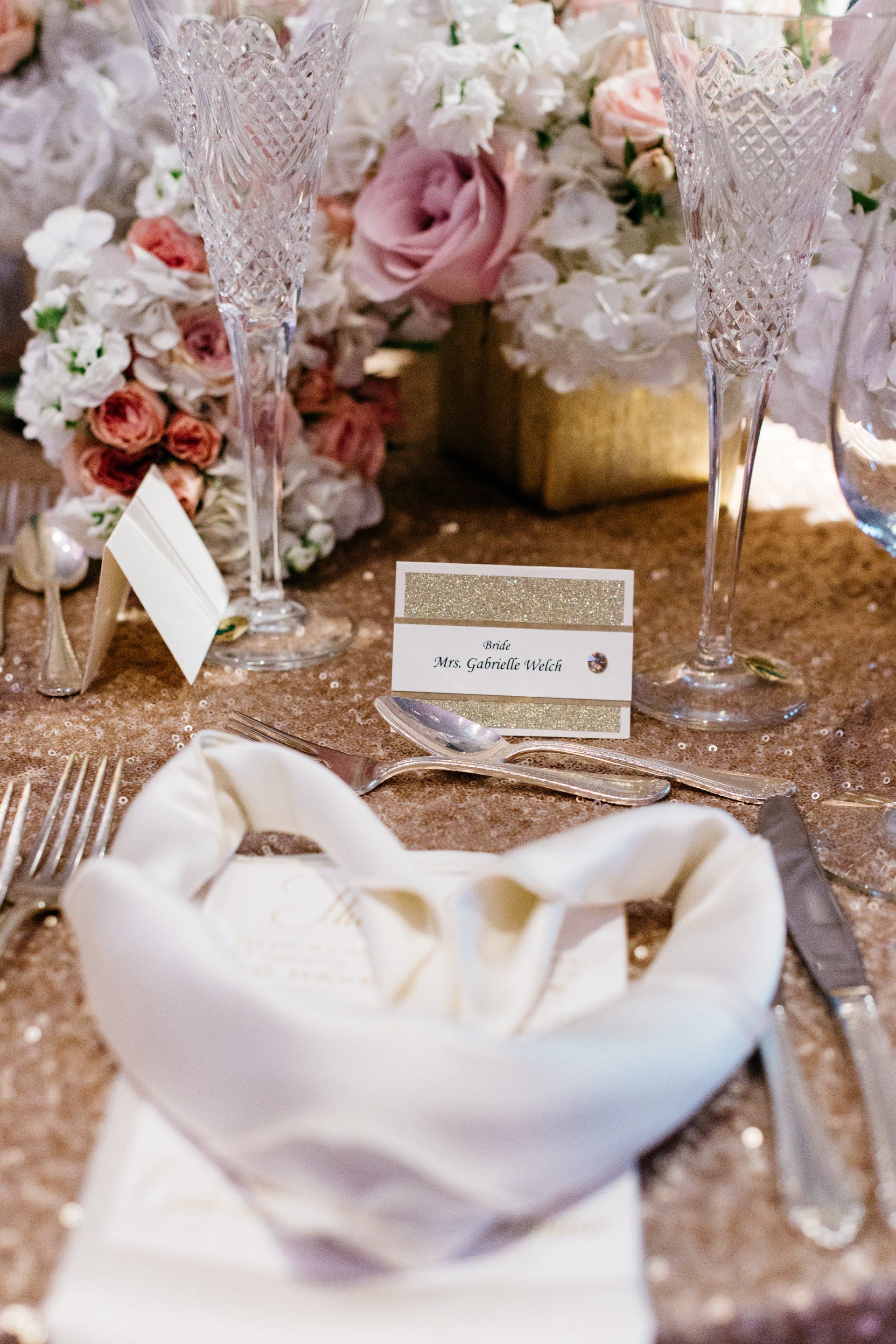 A place setting for a wedding with a napkin , silverware , and flowers.