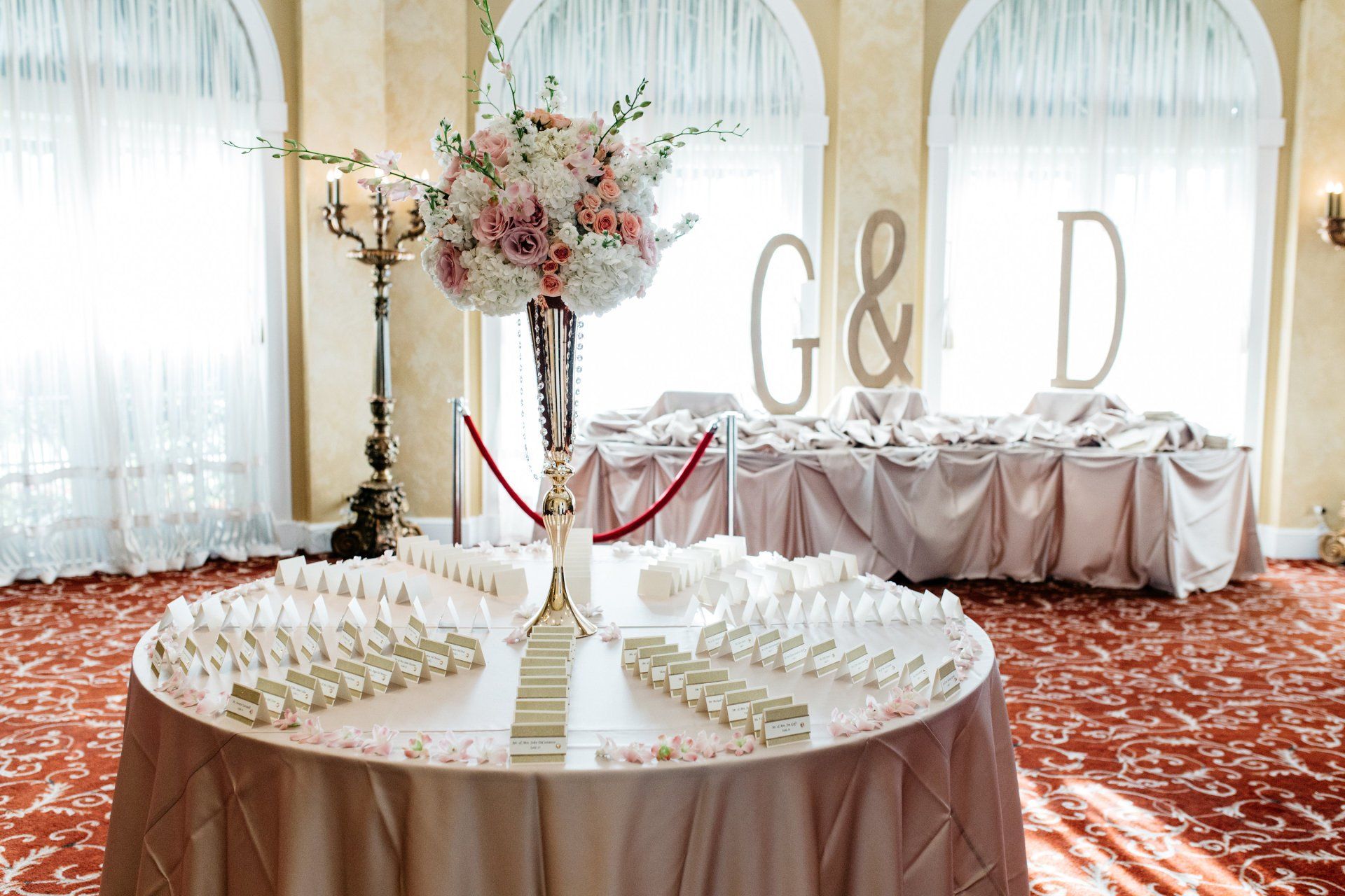 A table with a vase of flowers on it and the letters g and d on it