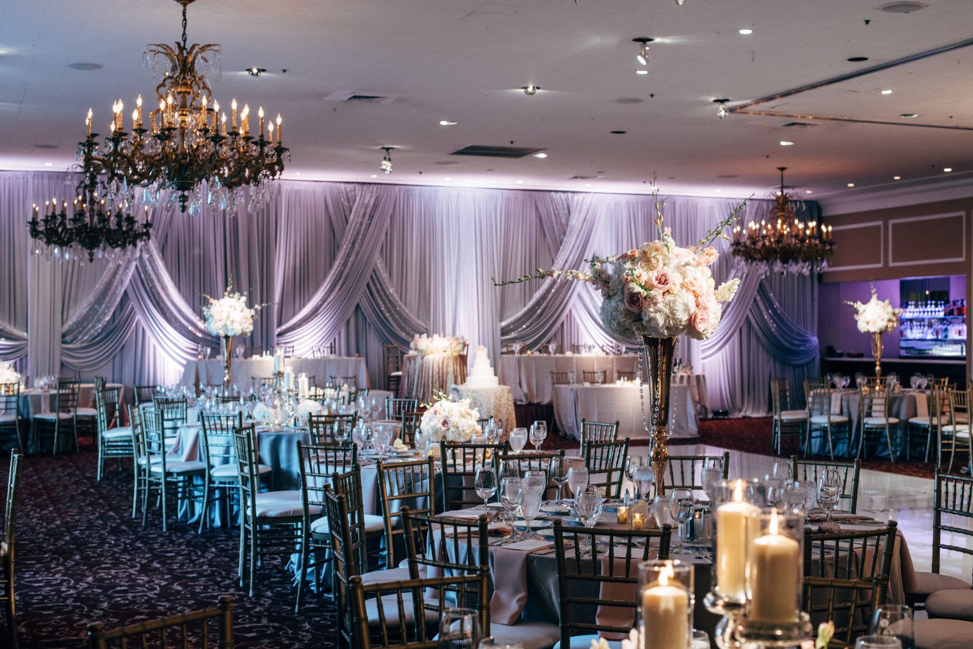 A large room with tables and chairs set up for a wedding reception.
