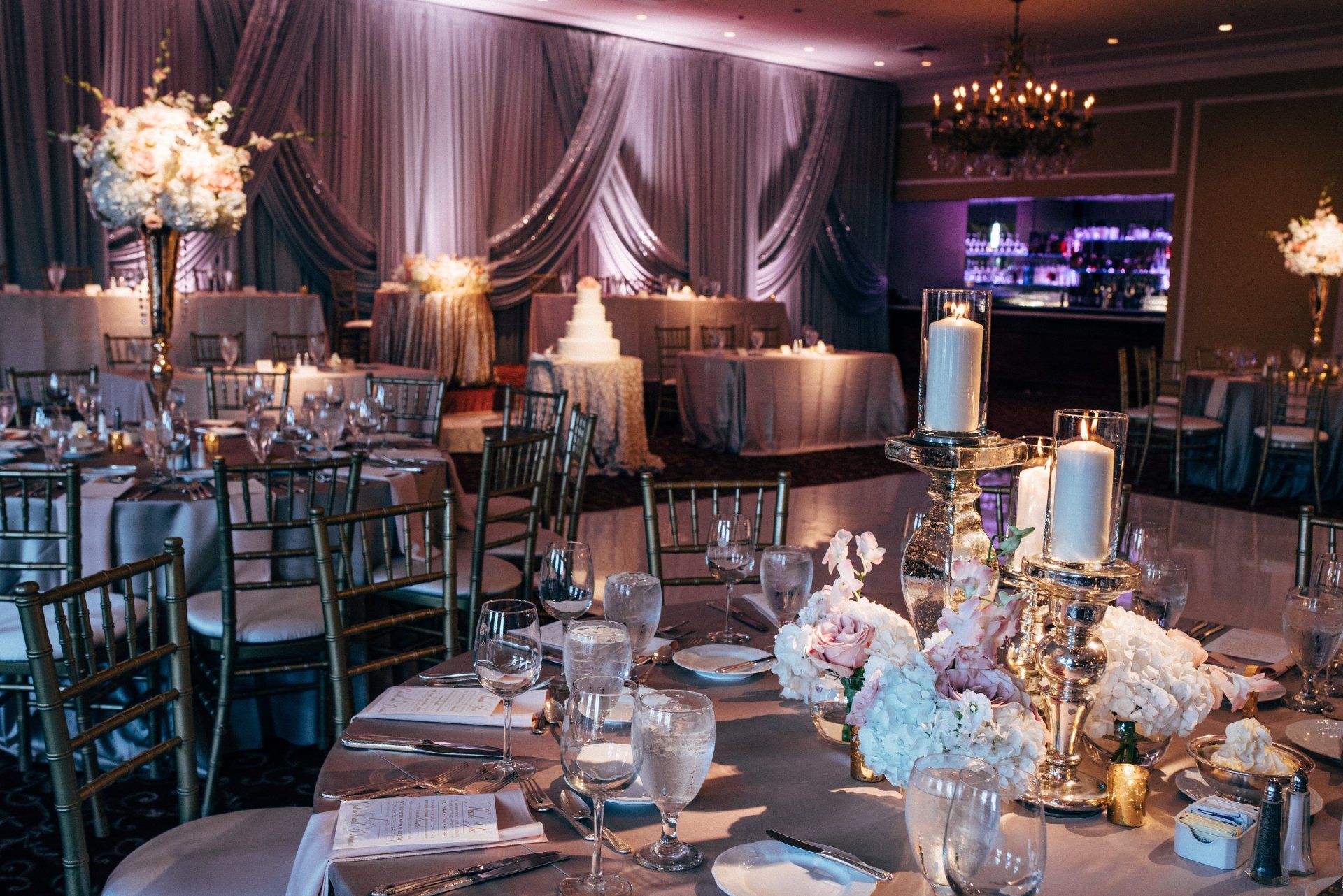 A large room with tables and chairs set up for a wedding reception.