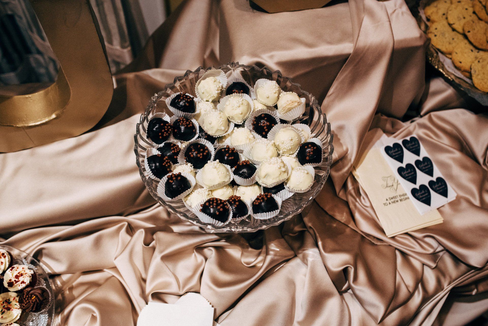 A glass plate filled with chocolate truffles is sitting on a table.