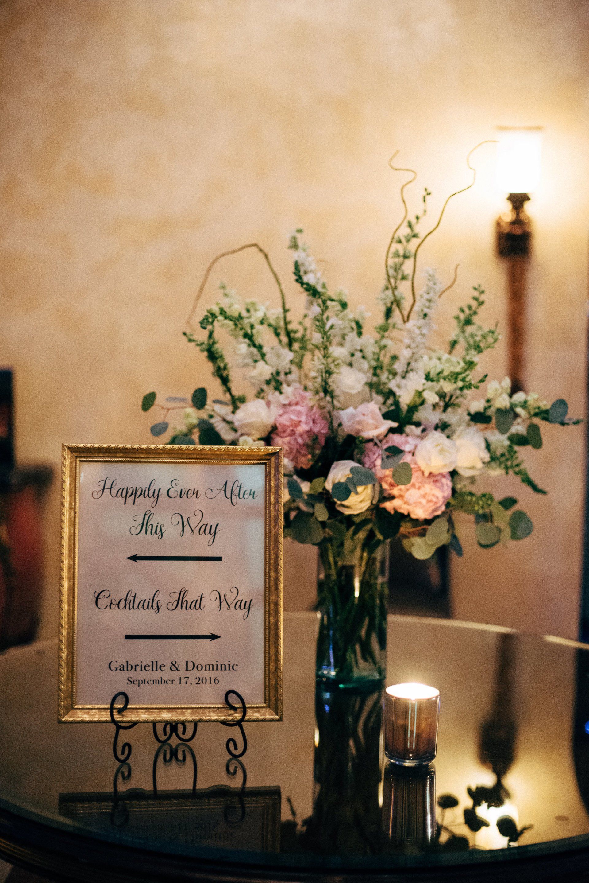 A vase of flowers and a sign on a table.