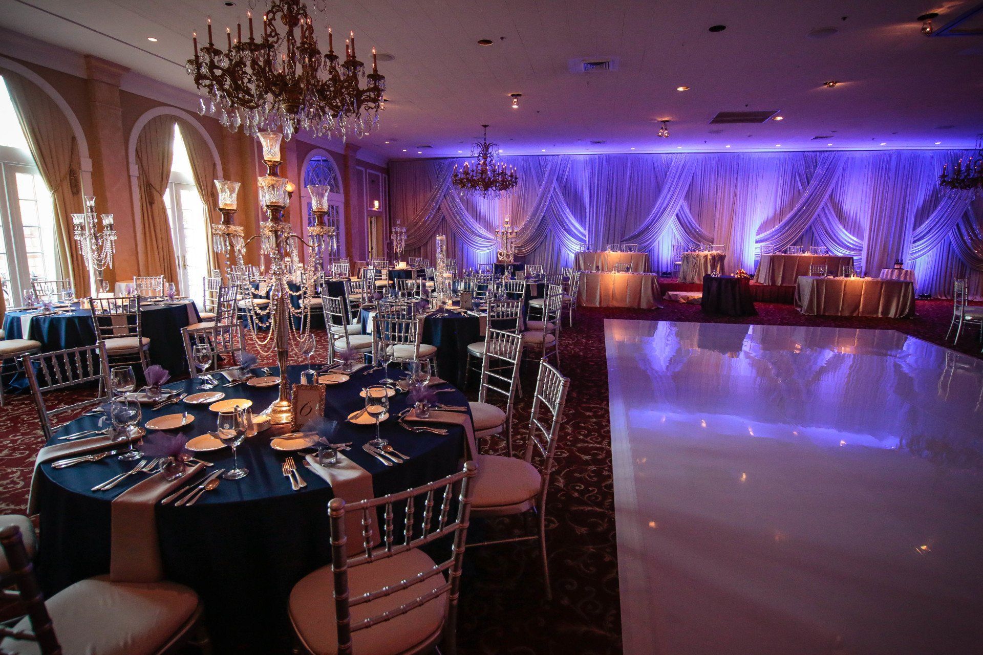 A large room with tables and chairs and a dance floor.