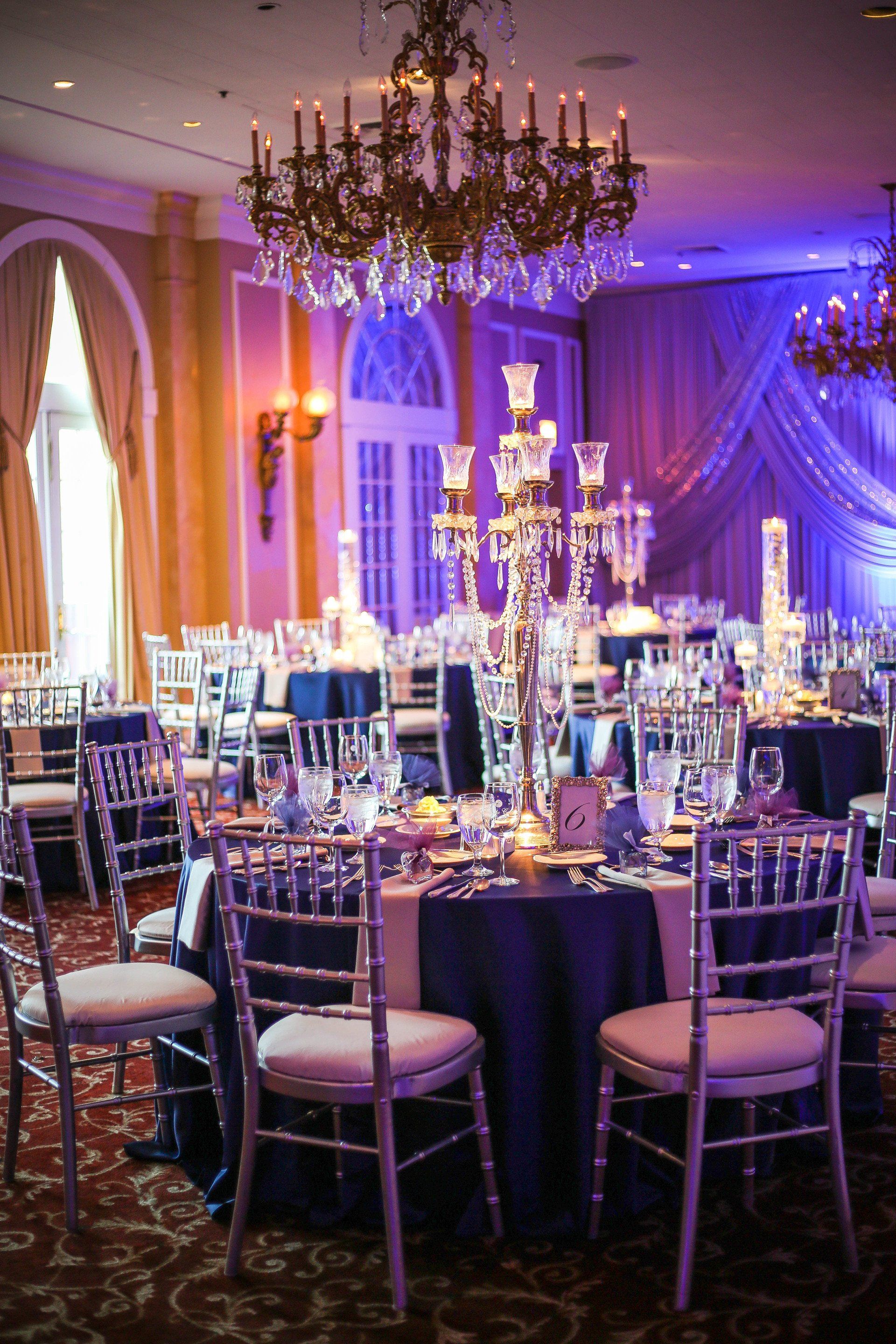 A large room with tables and chairs set up for a wedding reception.