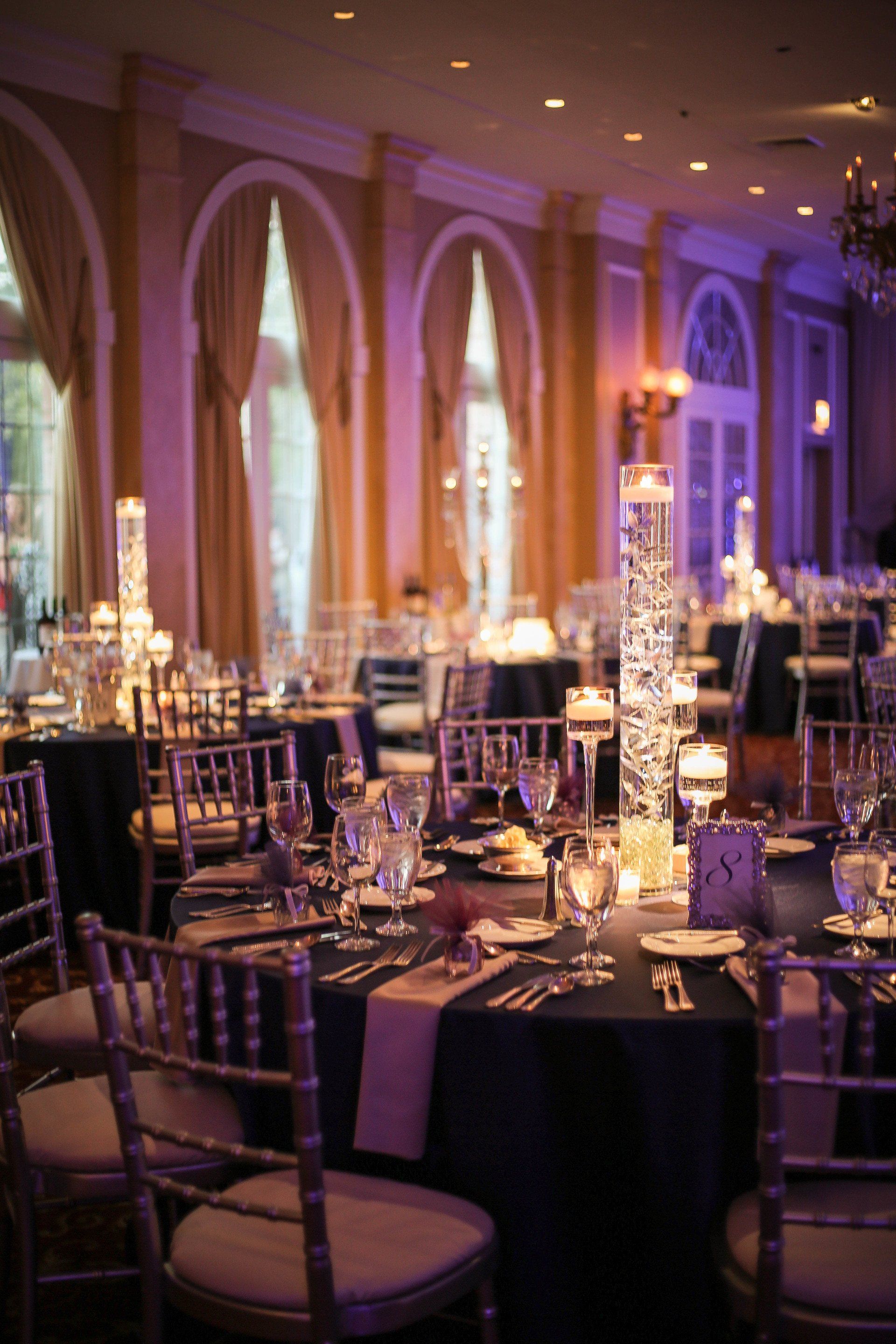 A large room with tables and chairs set up for a wedding reception.