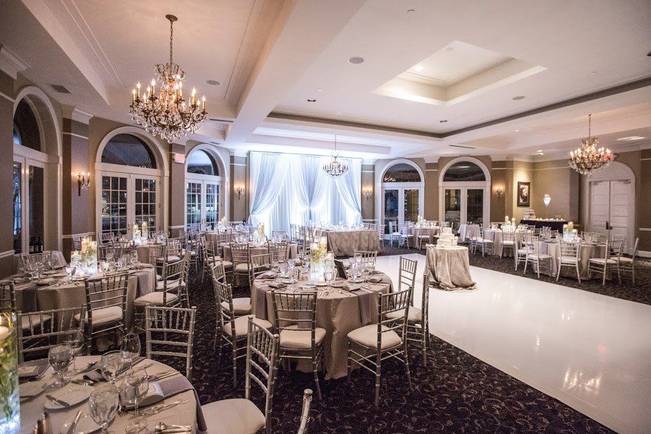 A large room with tables and chairs set up for a wedding reception.