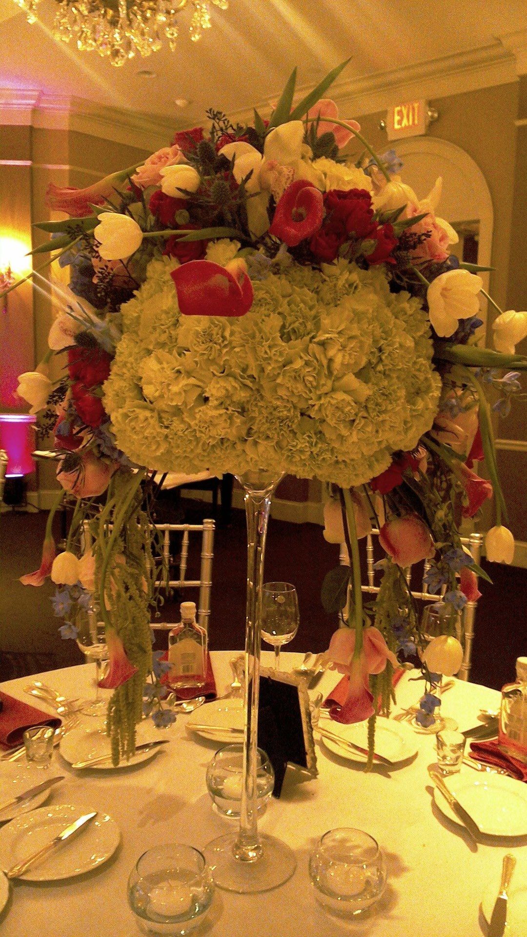 A tall vase filled with flowers is on a table.