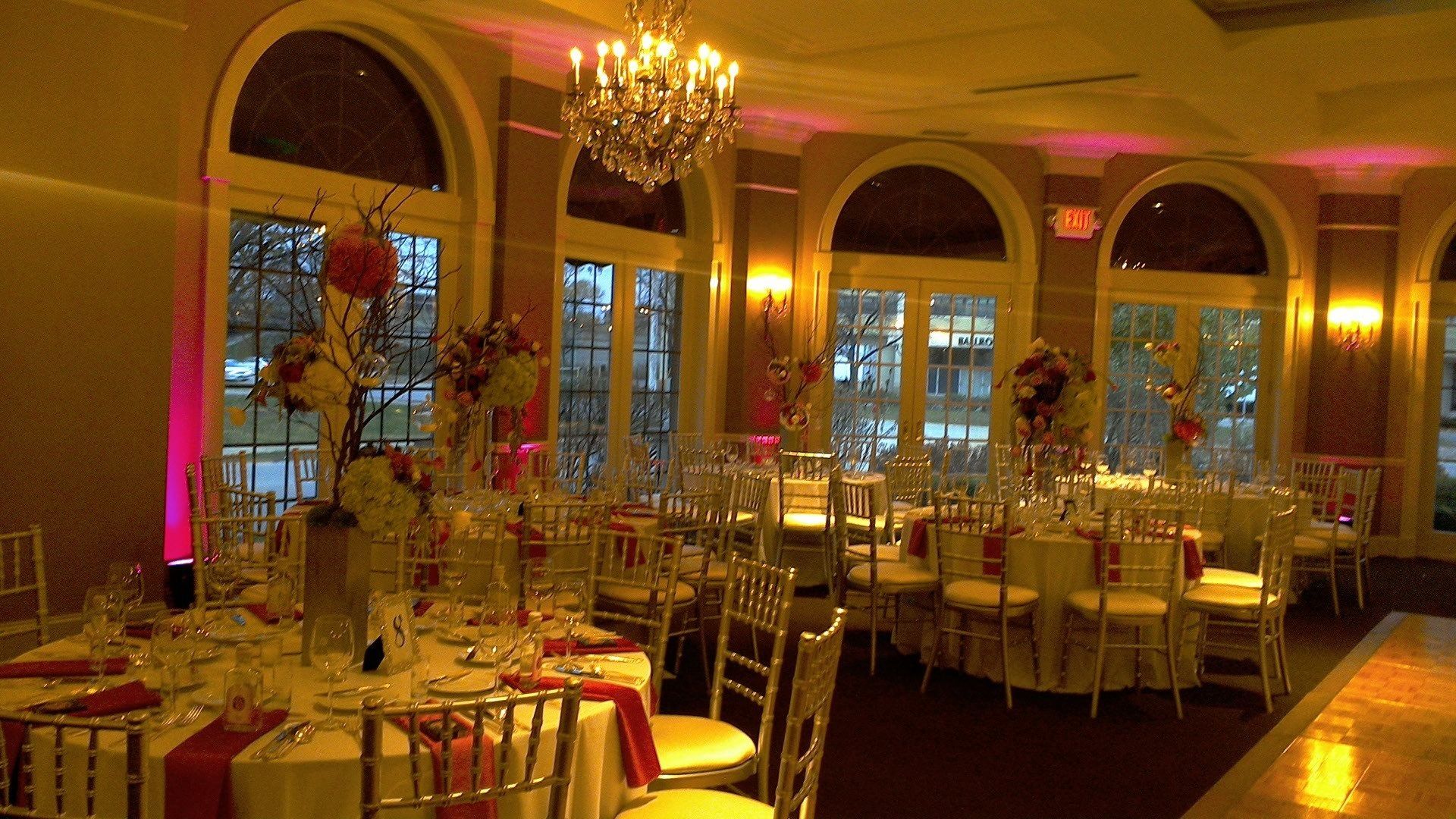 A large room with tables and chairs set up for a wedding reception.