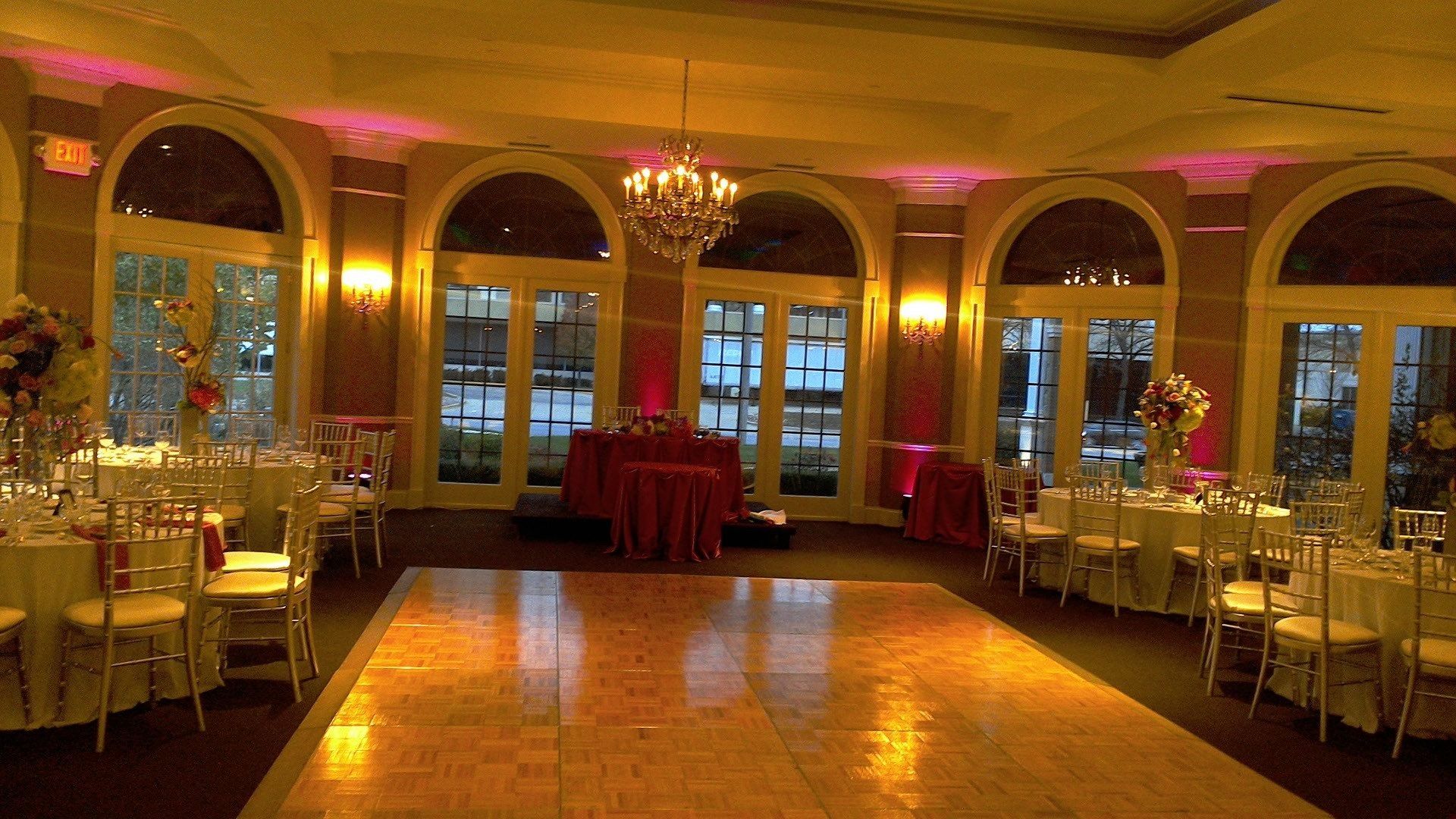 A large room with tables and chairs and a dance floor.
