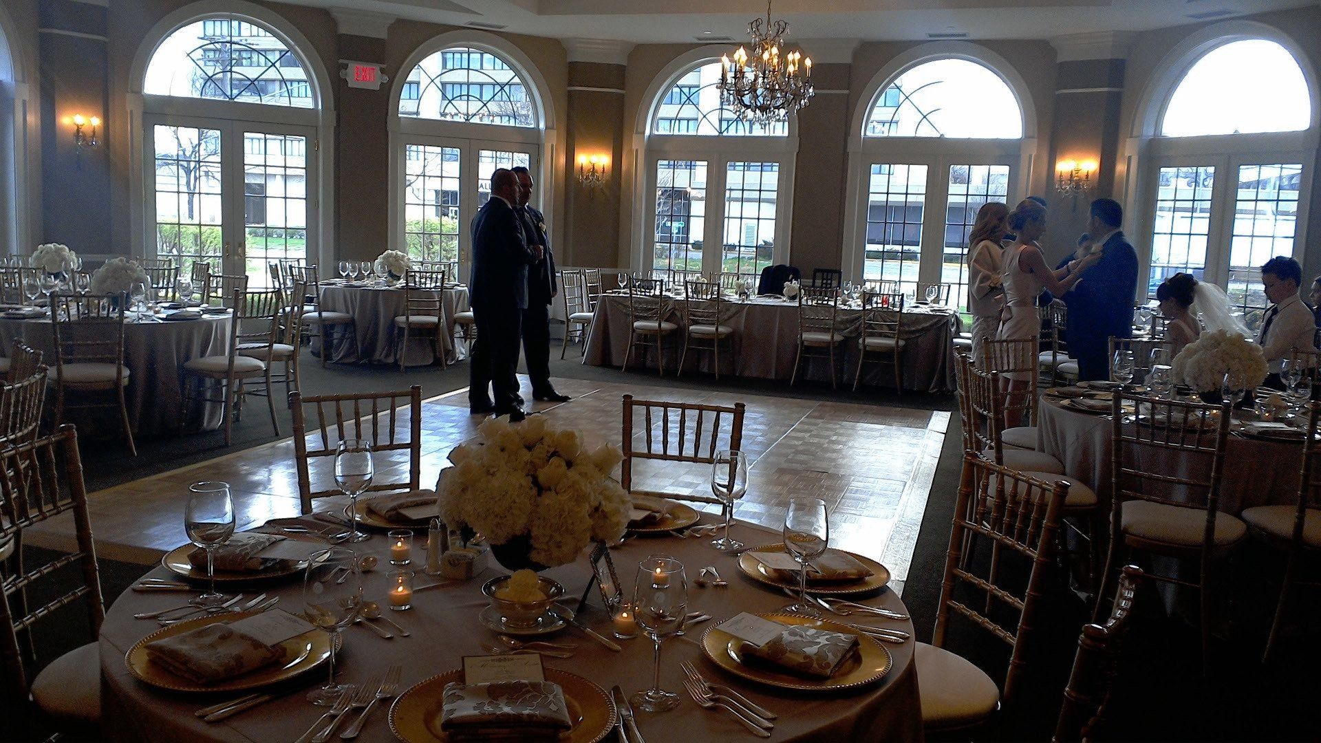 A large room with tables and chairs set up for a wedding reception.