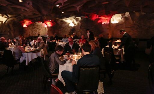 A group of people are sitting at tables in a restaurant.