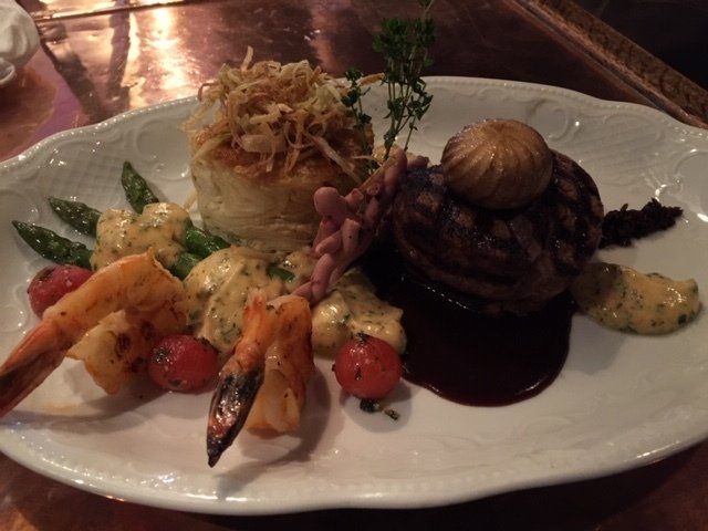 A plate of food with meat and vegetables on a table