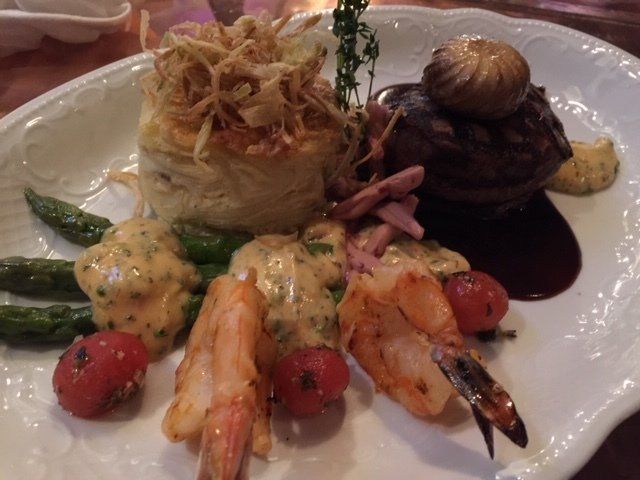 A plate of food with shrimp and asparagus on a table.