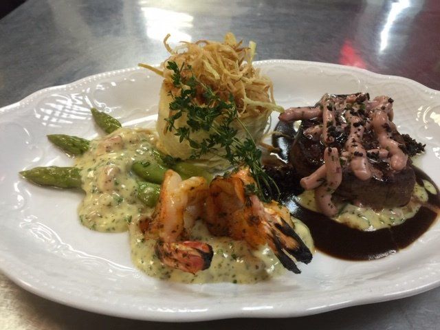 A plate of food with shrimp and asparagus on a table