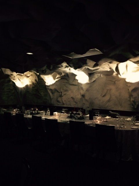 A dining room with tables and chairs in the dark