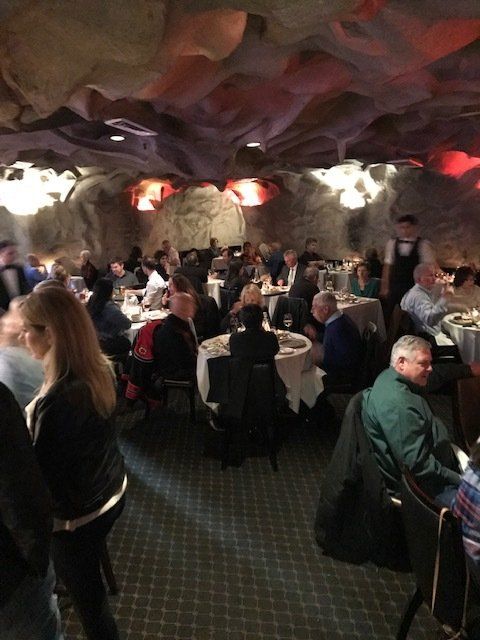 A group of people are sitting at tables in a restaurant.