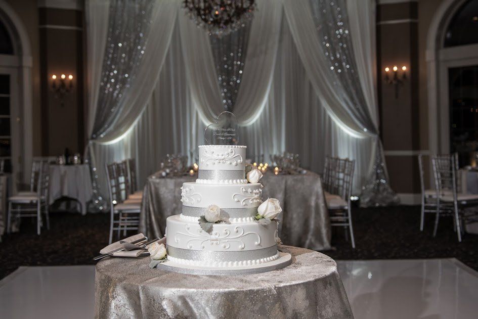 A wedding cake is sitting on top of a table in a room.