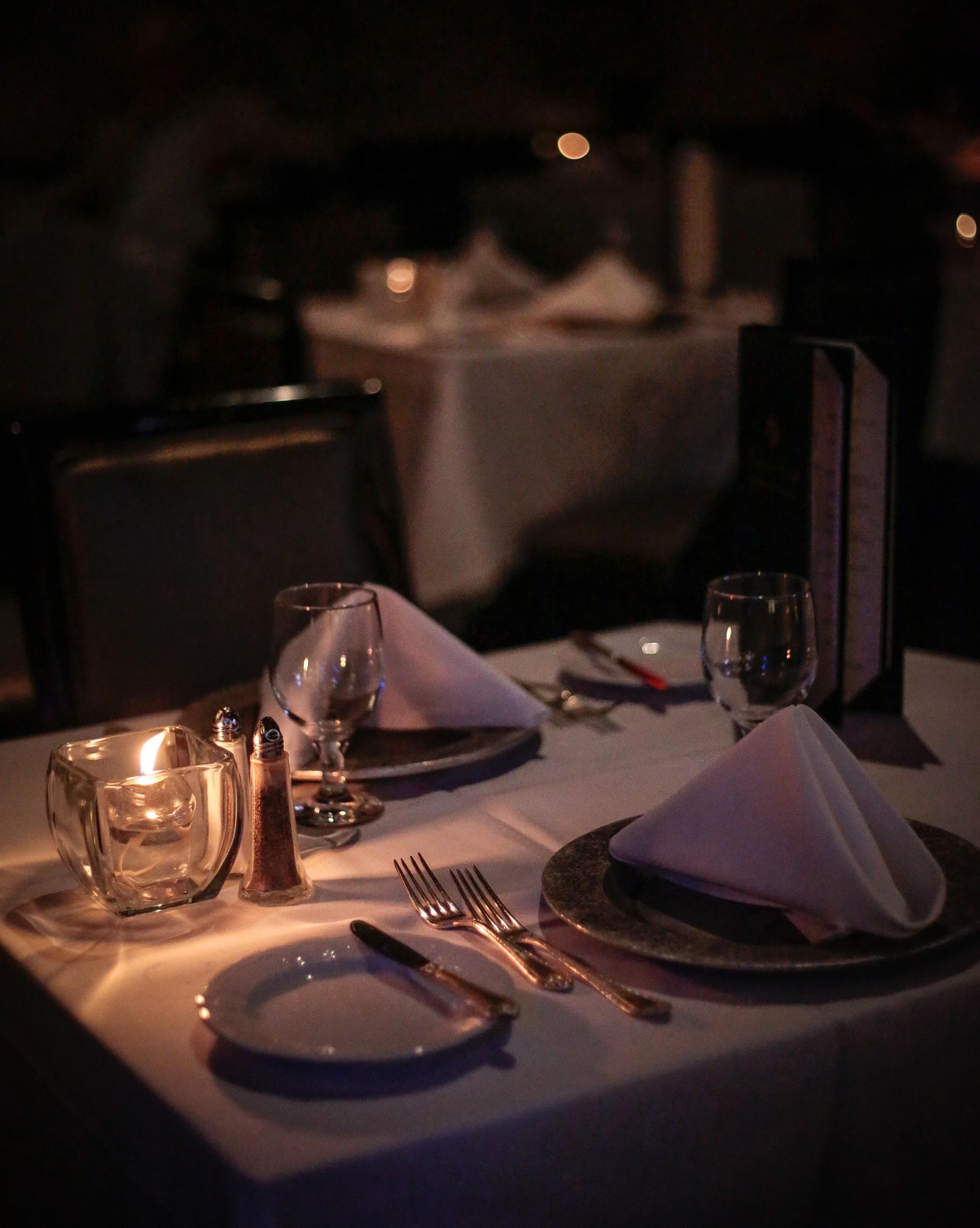 A table set for dinner with plates glasses and napkins