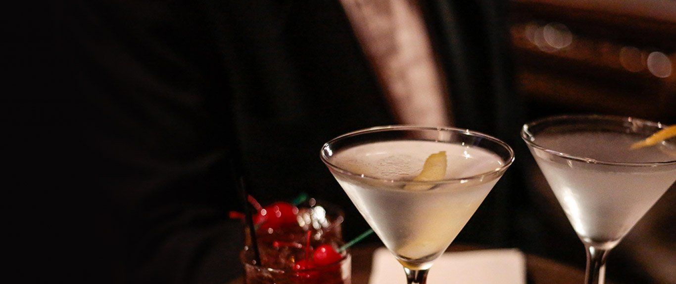 Two martini glasses are sitting on a table.