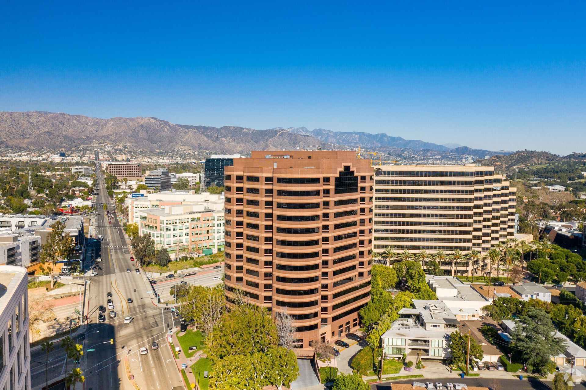 An aerial view of a city with a large building in the middle of it.