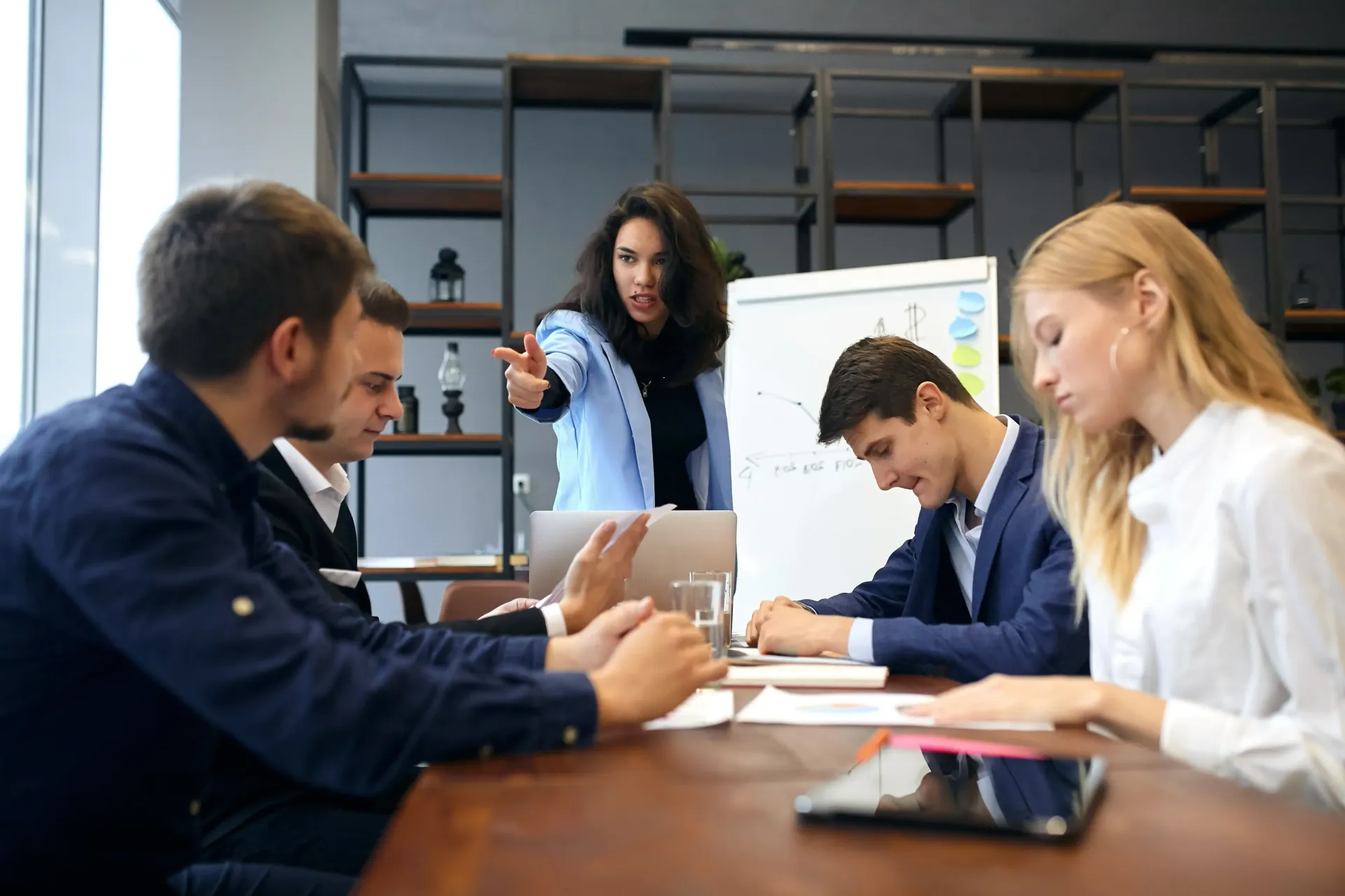 A group of people are sitting around a table having a meeting.