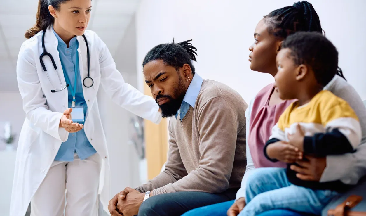 Doctor speaking to a concerned family in a waiting room.