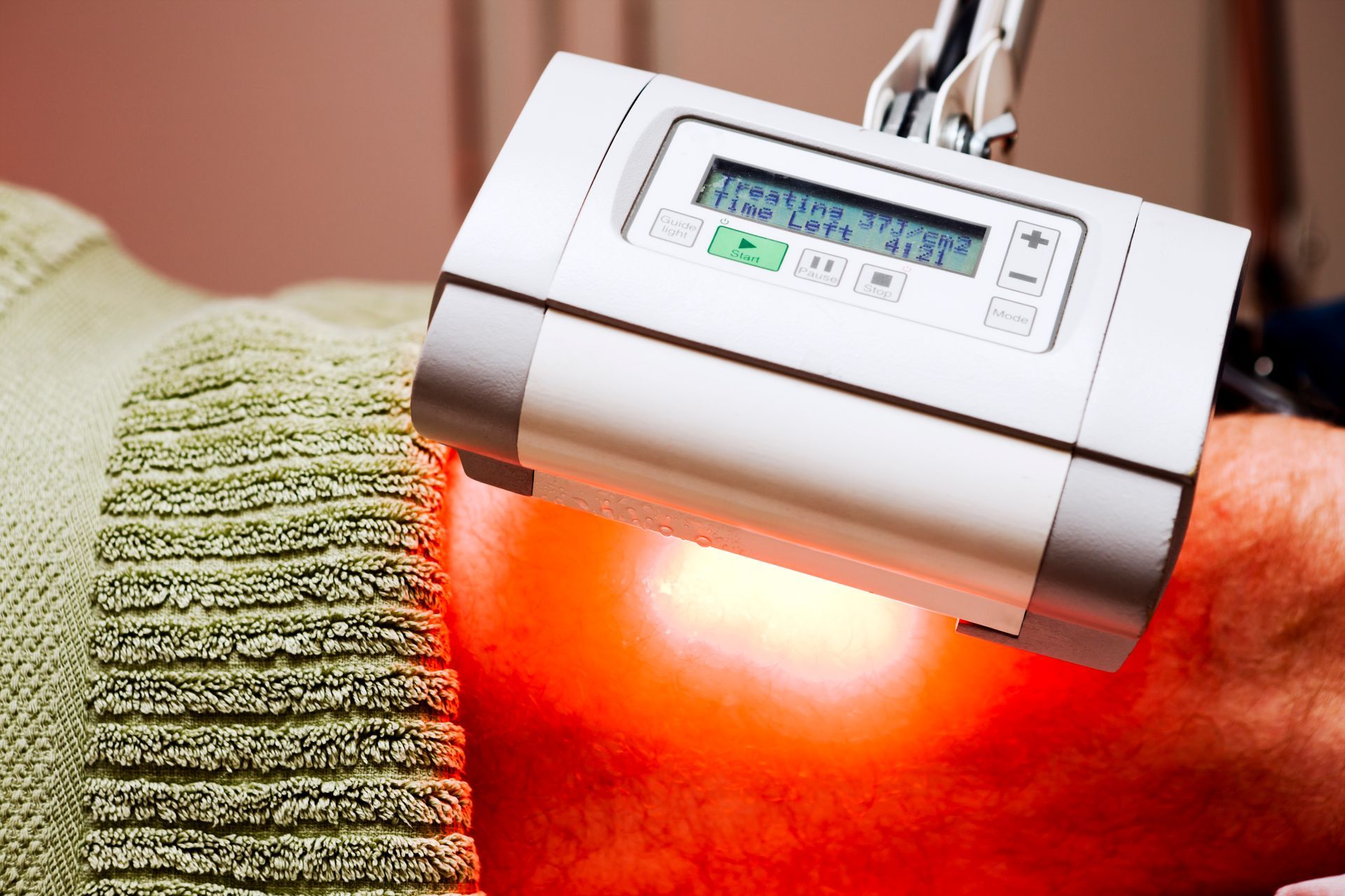 A person is getting a red light treatment on their arm