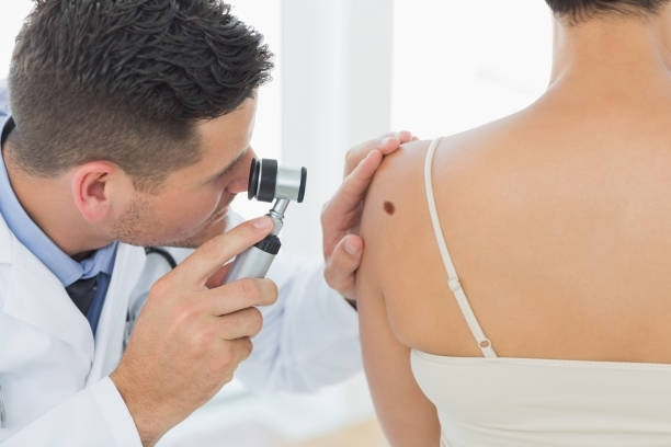 A doctor is examining a woman 's back with a magnifying glass.