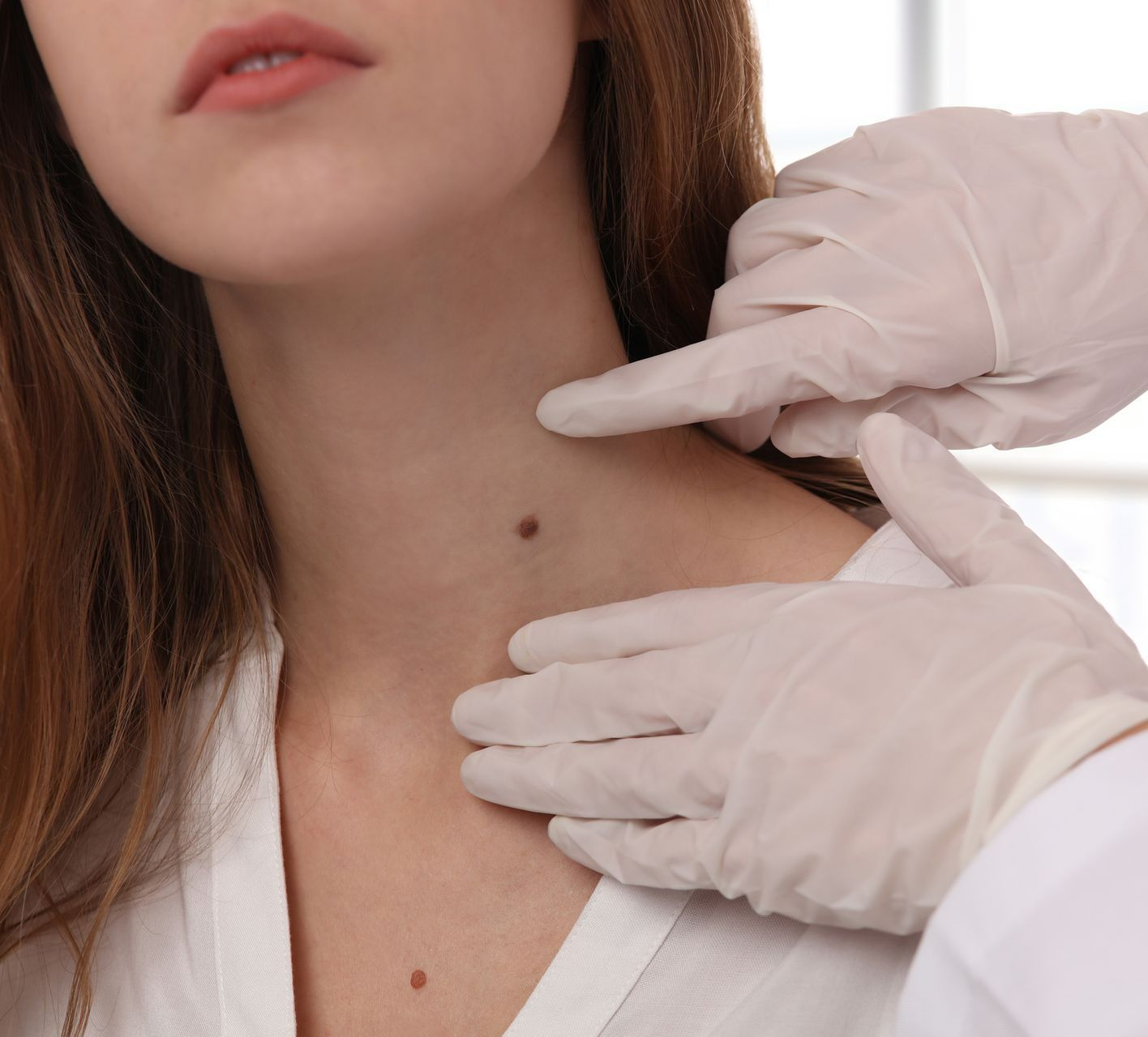 A woman is getting her neck examined by a doctor