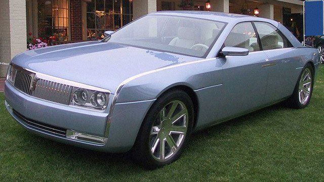 A blue car is parked in the grass in front of a building