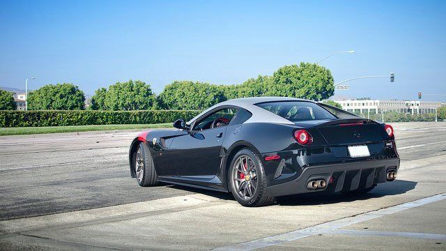 A black and white sports car is parked in a parking lot.