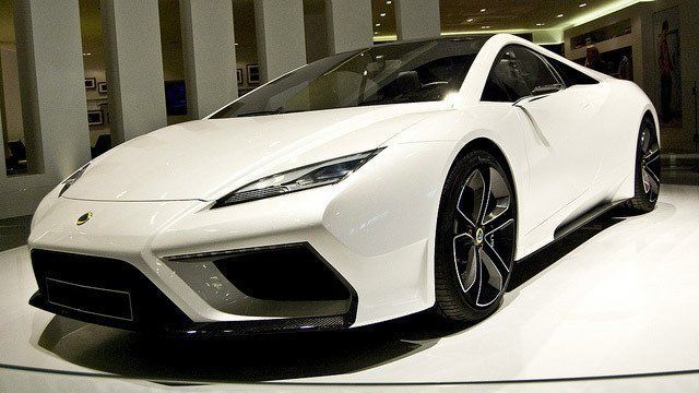 A white sports car is parked on a white surface.