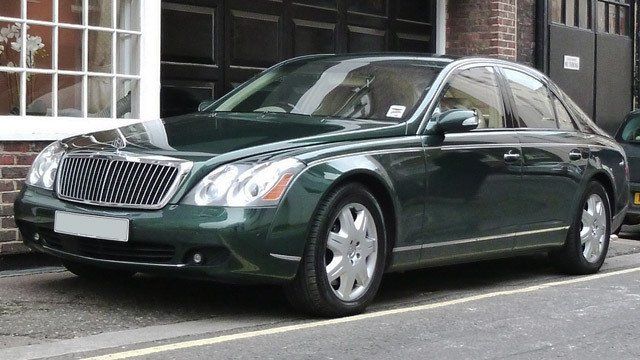A green mercedes maybach is parked on the side of the road