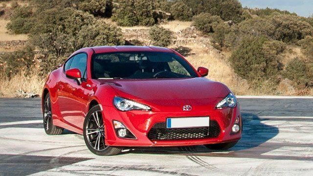 A red toyota scion fr s is parked on the side of the road.