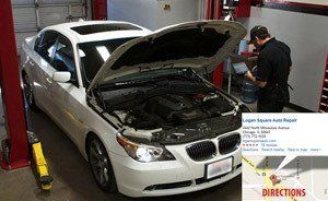 A man is working on a white car with the hood open.