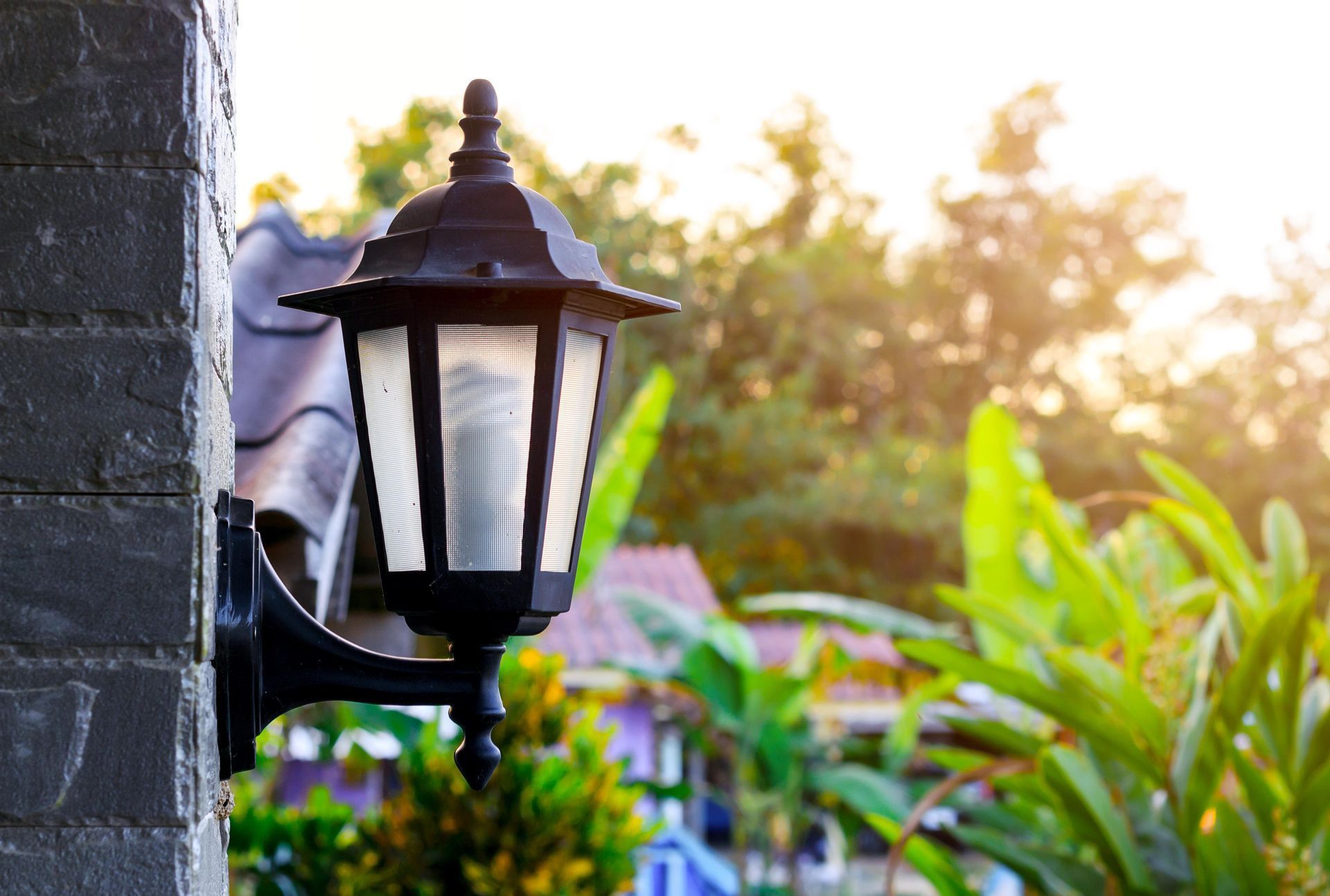 A black lamp is mounted on the side of a brick building.