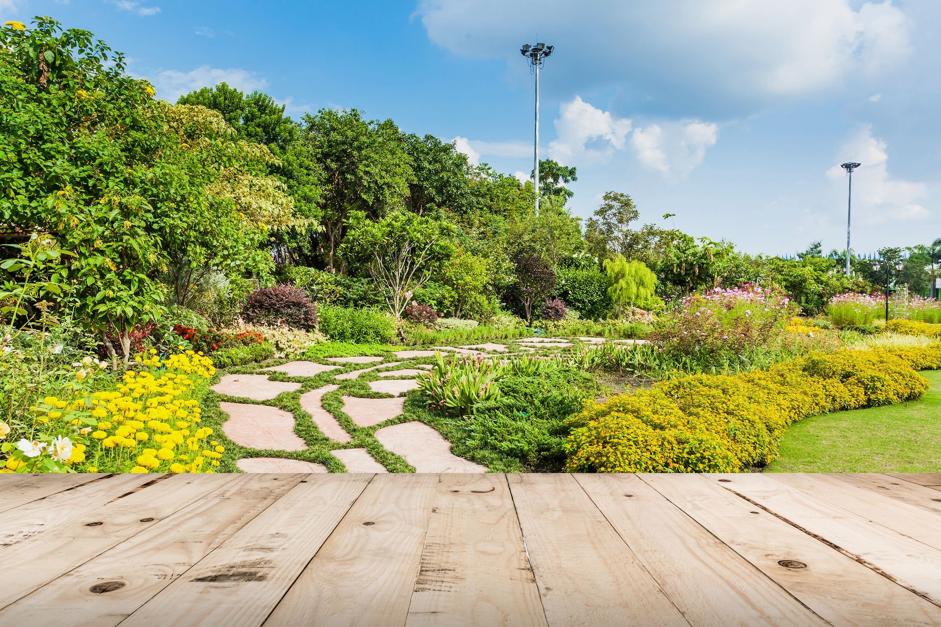 There is a wooden table in the foreground and a garden in the background.