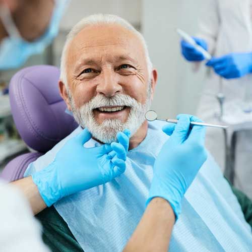 Happy senior man having dental treatment at dentist's office