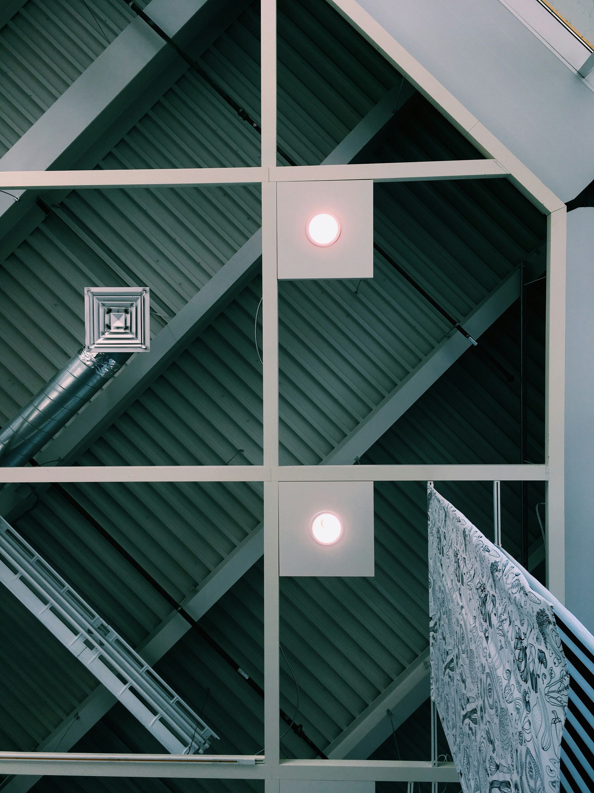 The ceiling of a building has a square light on it