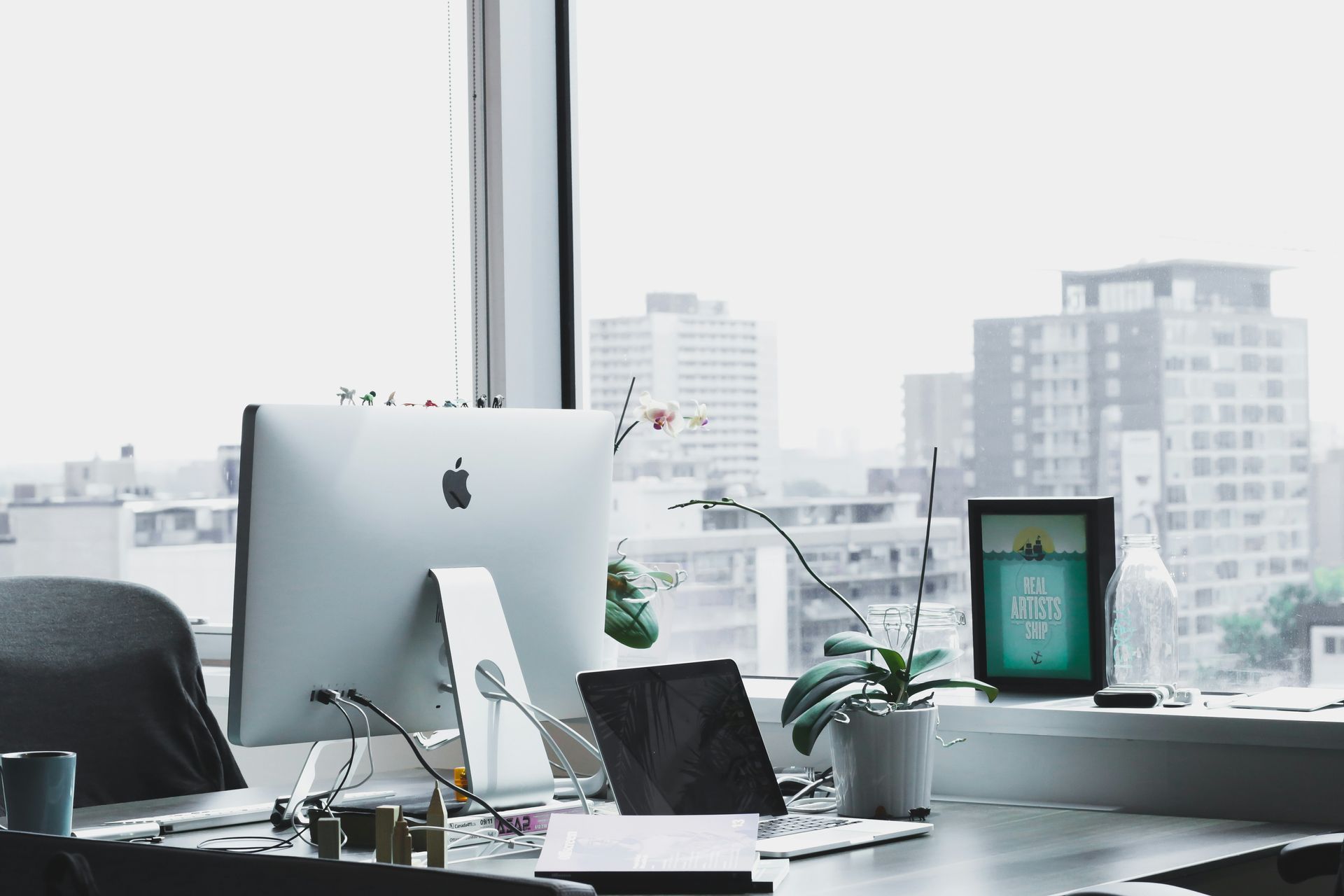 A desk with a computer and a laptop on it.