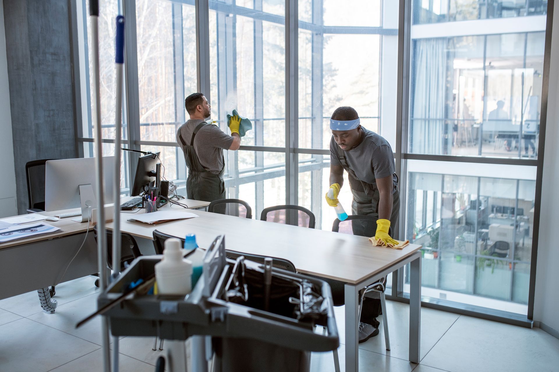 Two men are cleaning the windows of an office building.