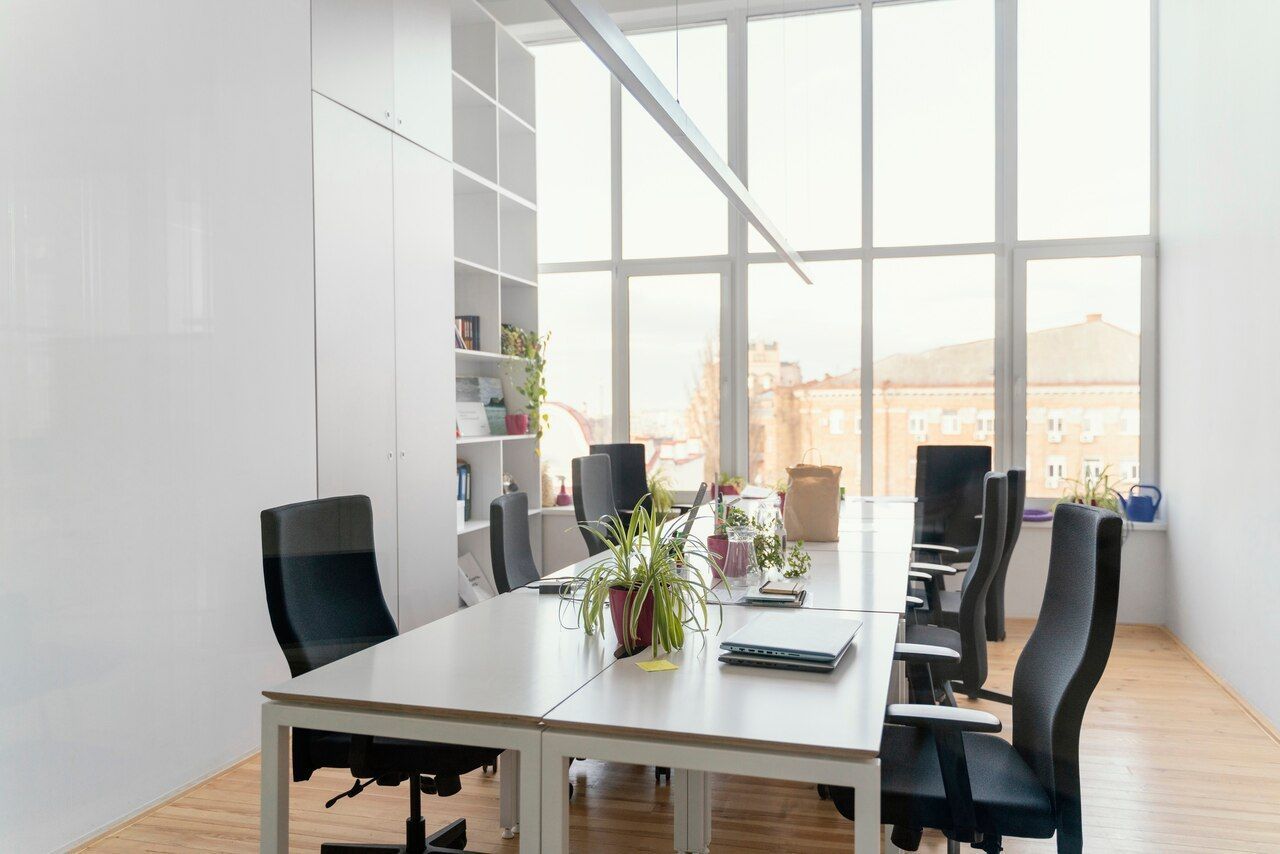 A conference room with a long table and chairs and a lot of windows.