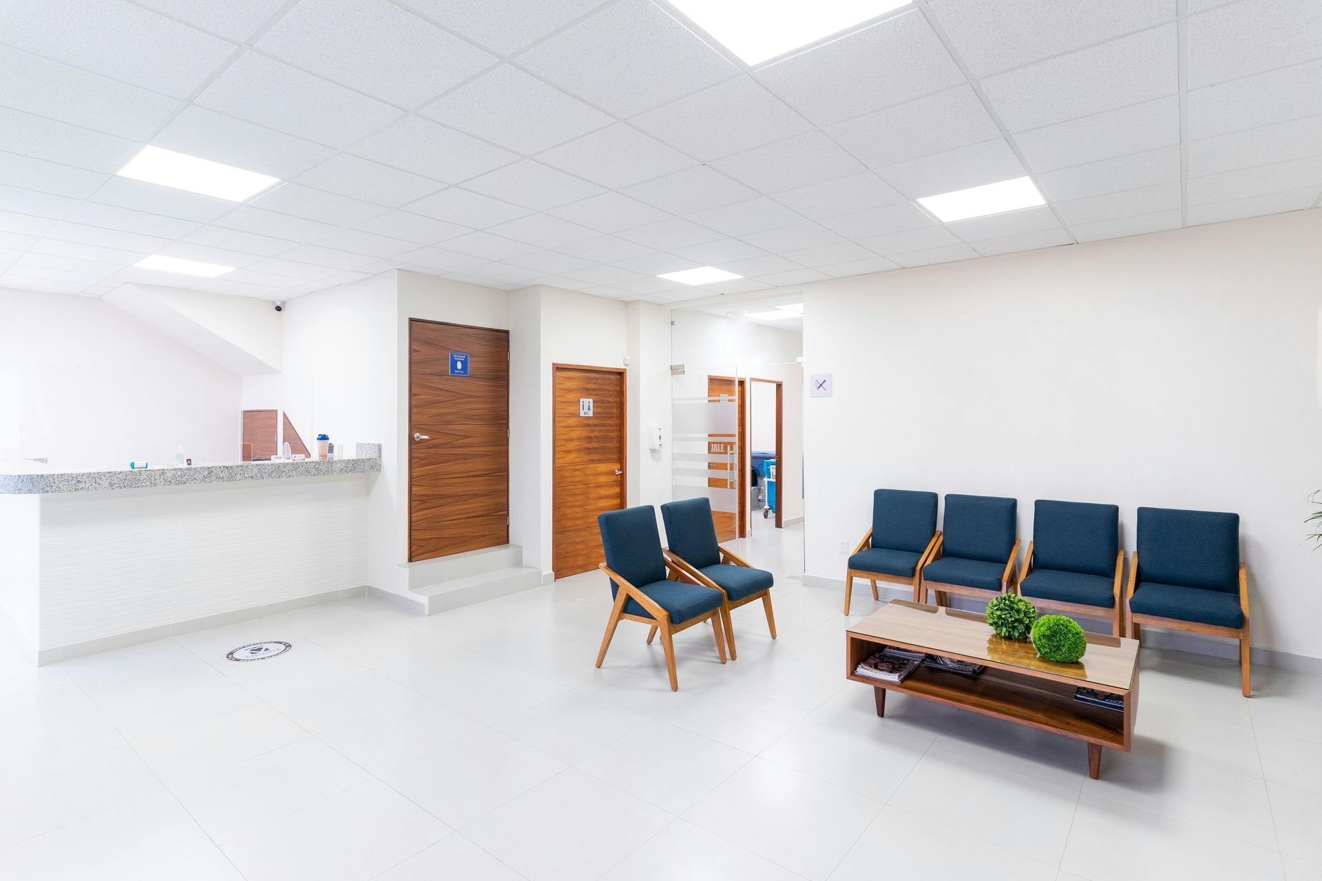 A waiting room with chairs and a coffee table in a hospital.