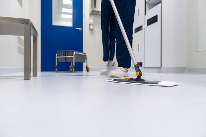 A person is cleaning the floor with a mop in a hospital.