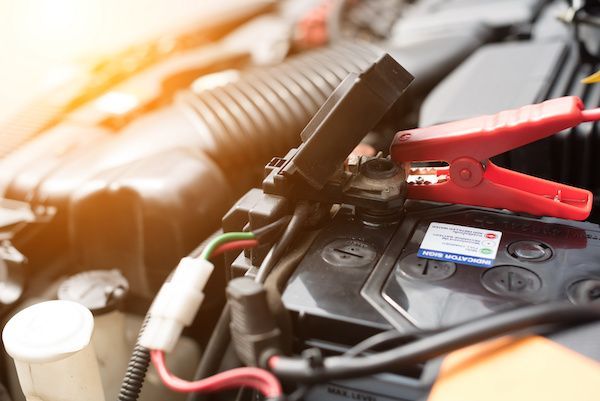 Car battery being jumped with red and black jumper cables. | Dave's Automotive LLC