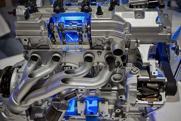 Cutaway view of a car engine, highlighting internal components with blue lighting and metallic finishes. | Dave's Automotive LLC