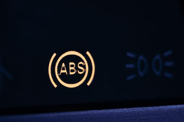 Illuminated amber ABS warning light on a vehicle dashboard. | Dave's Automotive LLC